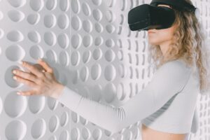 woman with a virtual reality headset with a hand on the wall